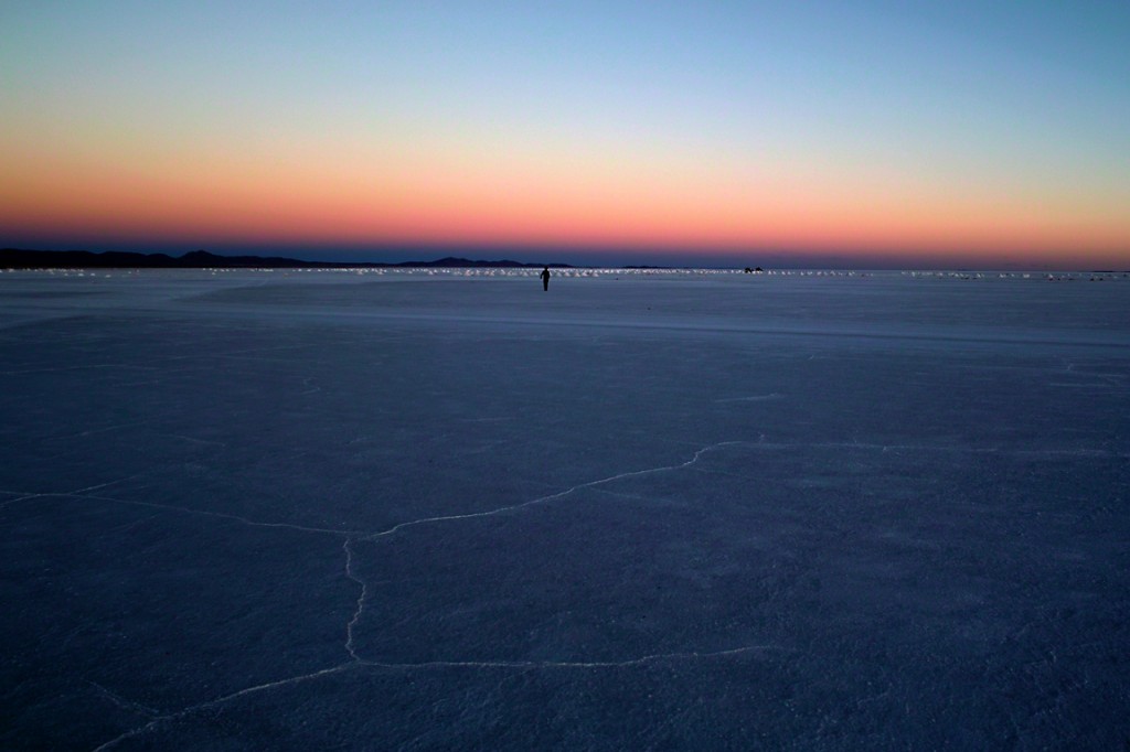 夕暮れのウユニ塩湖を歩く人