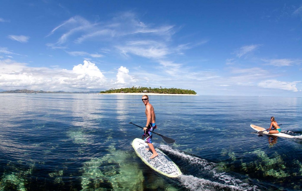 サーフボードでタバルア島へ向かう人々
