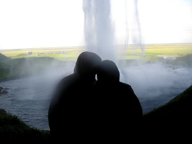 セリャラントスフォスの滝の裏側で寄り添うカップル