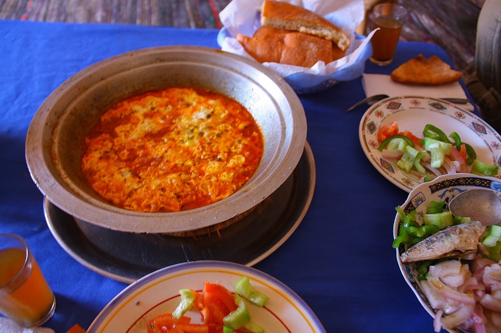 サハラ砂漠の中で食べるモロッコ料理の画像です。